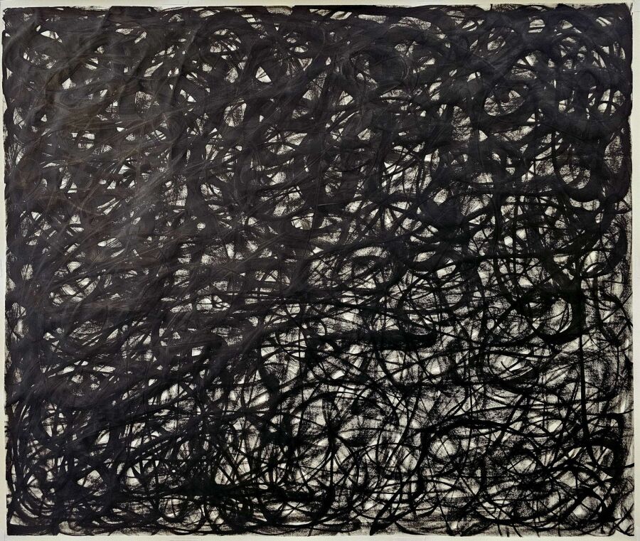 Loose black scribbled loops layered into a heavy mass that gathers toward the right side of the sheet.