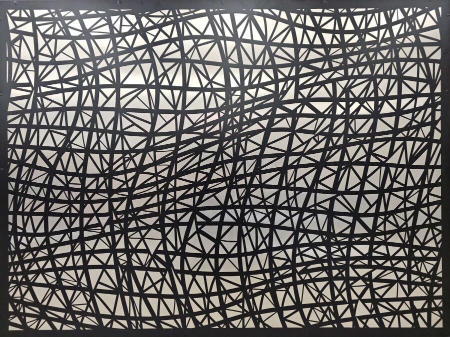 Aluminum panel covered in a web of straight black lines crossing at sharp angles over a pale ground.