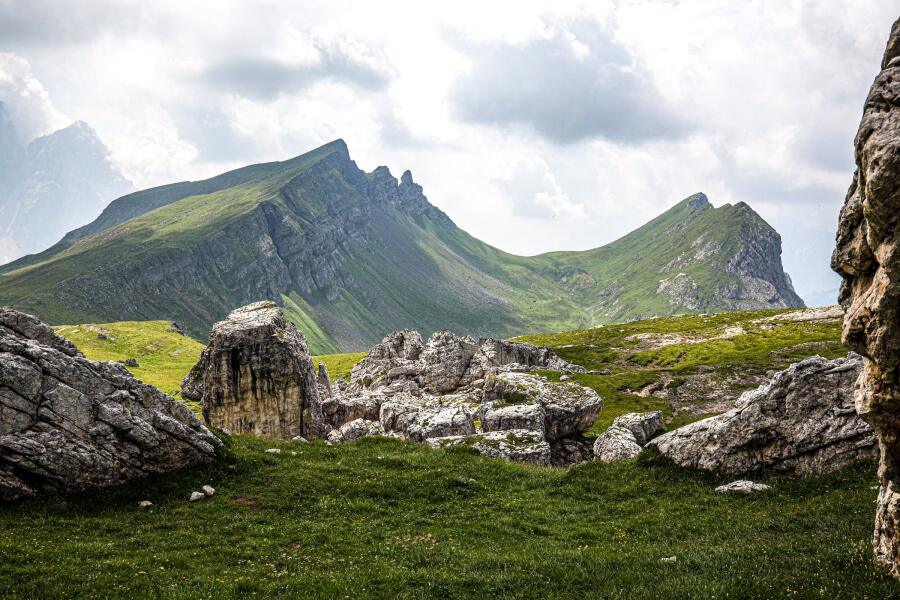 A grassy ridge line running up to a rocky summit, framed between two large pale boulders.