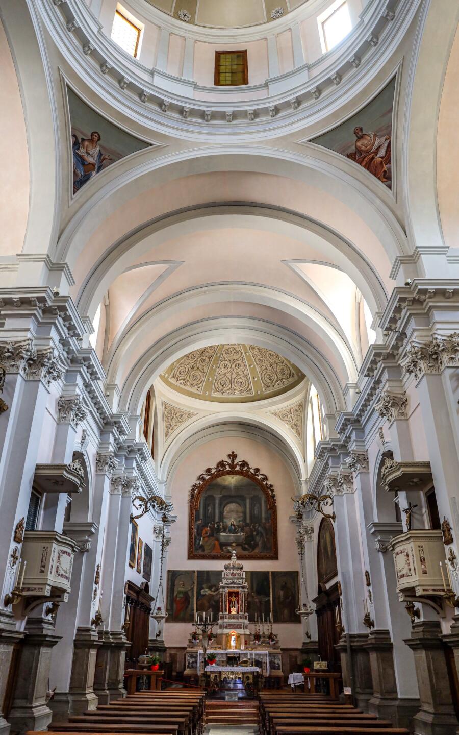 A neoclassical church interior with a coffered dome and barrel vault above the crossing.